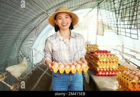 Agricoltore asiatico donna, ritratto e produzione di uova per la piccola impresa biologica, sostenibilità e sorriso. Buon esperto di allevamento del pollo, successo e visione Foto Stock