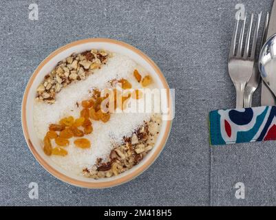 Pasto a base di dessert a base di budino di riso alla carta con scaglie di cocco e uva sultanina in cima Foto Stock