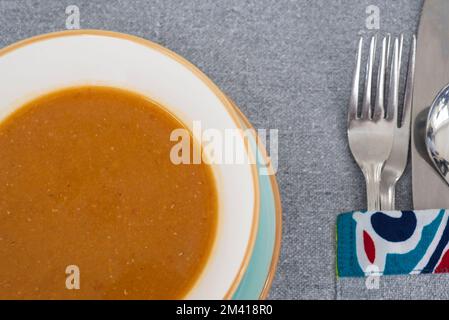 Primo piano di zuppa di lenticchie a la carte antipasto pasto in recipiente con posate al tavolo del ristorante Foto Stock