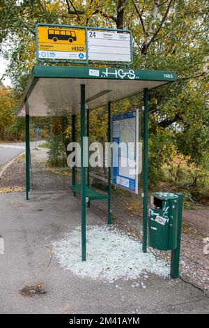 Vandalized fermata di autobus rifugio con stalle brokenglass sul terreno nel quartiere Vähä-Meilahti di Helsinki, Finlandia Foto Stock