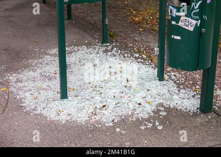 Shards sul terreno intorno al rifugio vandalizzato fermata autobus nel quartiere Vähä-Meilahti di Helsinki, Finlandia Foto Stock