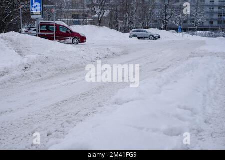 Tallinn, Estonia - 13 dicembre 2022: Condizioni meteorologiche difficili. Strada e marciapiede sotto cumuli di neve. Traffico pericoloso. Foto Stock