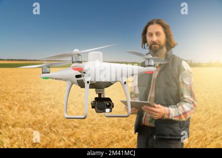 Farmer controlla il drone con un tablet. Agricoltura intelligente e agricoltura Foto Stock