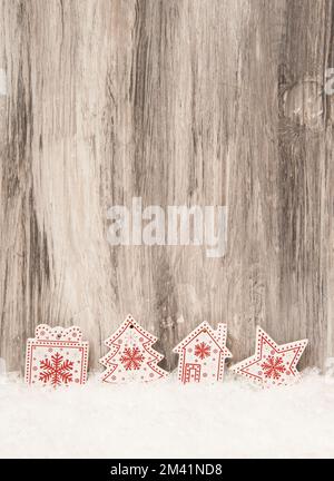 Natale sfondo in legno con decorazioni in legno rosso e bianco e neve artificiale Foto Stock