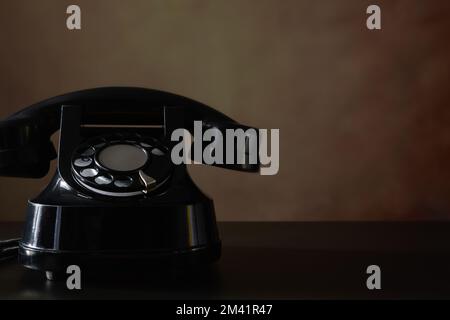 Vecchio telefono su un tavolo di legno con vecchio sfondo. Vintage - vita ferma. Foto Stock