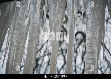 Ghiaccioli appesi dal tetto contro il cielo Foto Stock