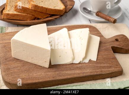 Formaggio Canastra fresco artigianale con pane su tavola di legno. Foto Stock