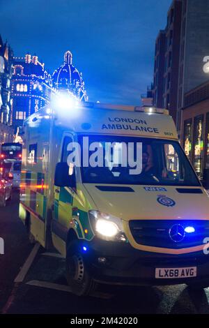 Londra, Regno Unito, 17 dicembre 2022: Un'ambulanza di emergenza lo fa attraversare il traffico pesante a Knightsbridge, con le luci di Natale sullo sfondo. In Inghilterra e Galles i conducenti di ambulanze dei sindacati GMB, Unison e Unite dovranno scioperarsi il 21 dicembre in una disputa sulla retribuzione. Anna Watson/Alamy Live News Foto Stock