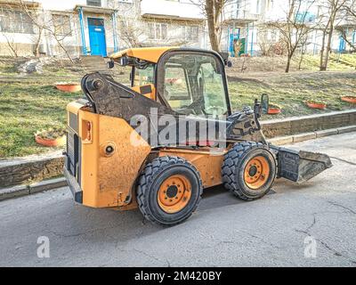 Caricatore frontale piccolo per il carico e lo scarico sulle strade cittadine Foto Stock