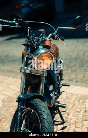 Un primo piano verticale di una moto d'epoca catturata nelle strade di Lisbona, Portogallo Foto Stock