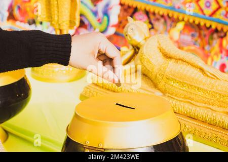 Donare denaro per aiutare il tempio nel festival annuale della sfilata arancione o Chak Phra Festival che ha avuto luogo nel sud della Thailandia in autunno, è un de Foto Stock