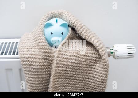 Radiatore di riscaldamento con piggy bank e abiti caldi interni Foto Stock