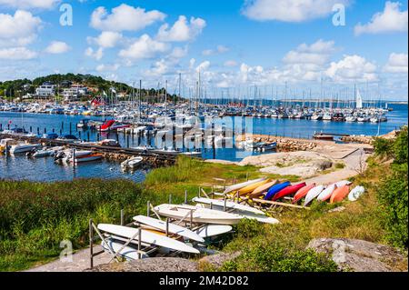 Pittoresco villaggio costiero con barche a vela e imbarcazioni nautiche ormeggiate. Foto Stock