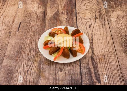 Piatto di falafel e hummus a fette con pomodoro a fette e lattuga Foto Stock