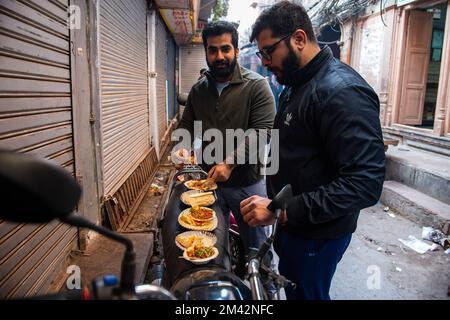 Vecchia Delhi, India. 18th Dec, 2022. I buongustai si trovano sulla strada stretta nella vecchia Delhi e mangiano il famoso Lotan Chole Kulche, un negozio di cibo di strada indiano nella vecchia Delhi. (Credit Image: © immagini Pradeep Gaur/SOPA tramite ZUMA Press Wire) Foto Stock