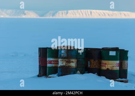 Vecchie botti di olio arrugginito di fronte alla montagna della Groenlandia Foto Stock