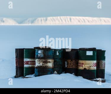 Vecchie botti di olio arrugginito di fronte alla montagna della Groenlandia Foto Stock