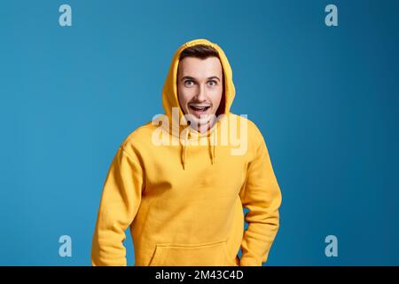 bell'uomo in felpa gialla su blu Foto Stock