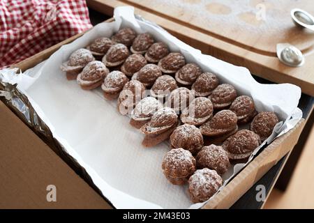 Biscotti di Natale fatti in casa a forma di noce in una scatola regalo su un tavolo Foto Stock