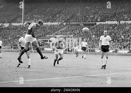 Foto del file datata 30-07-1966 di Geoff Hurst (secondo l) in Inghilterra dirige l'obiettivo di equalizzazione durante la finale della Coppa del mondo 1966, a cura del compagno di squadra Roger Hunt (c) e Wolfgang Weber (l) della Germania occidentale e Willi Schulz (r). Sir Geoff Hurst, che ha segnato un trucco quando l'Inghilterra ha vinto la finale di Coppa del mondo nel 1966, ha twittato: "Orgoglioso di ogni singolo giocatore e del modo in cui hanno giocato. Data di emissione: Domenica 18 dicembre 2022. Foto Stock