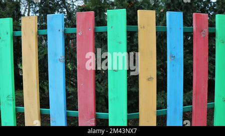 colorato legno dipinto struttura recinto tavola in un parco o giardino, multicolore legno tavola barriera per la decorazione di un esterno privato Foto Stock