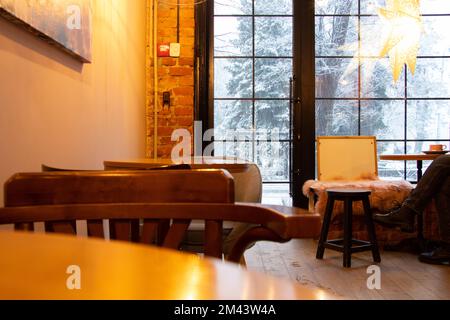 Cafe con vista sulla neve dalla finestra in Ucraina, l'interno del cafè con mobili in legno Foto Stock