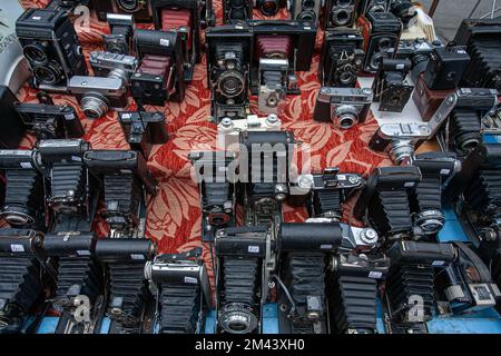 Un gruppo di vecchie macchine fotografiche vintage visualizzate su un tavolo in un mercato delle pulci a Londra, Regno Unito. Foto Stock