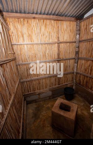 Una latrina di canna migliorata con una toletta di cemento in un cortile in Africa Foto Stock