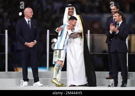 Lionel messi in Argentina abbraccia Emir of Qatar, Sheikh Tamim bin Hamad al Thani mentre il presidente della FIFA Gianni Infantino (a sinistra) e il presidente della Francia Emmanuel Macron (a destra) guardano alla vittoria sulla Francia con una sparatoria di rigore nella finale della Coppa del mondo FIFA allo stadio di Lusail a Lusail, in Qatar. Data immagine: Domenica 18 dicembre 2022. Foto Stock