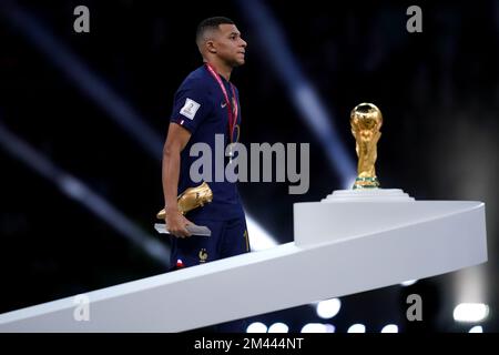 Vincitore del Golden Boot, il francese Kylian Mbappe sembra sconsolato mentre passa davanti al Trofeo della Coppa del mondo FIFA dopo aver subito la sconfitta in Argentina nella finale della Coppa del mondo FIFA al Lusail Stadium, Qatar. Data immagine: Domenica 18 dicembre 2022. Foto Stock