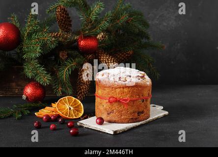 Panettone fatto in casa su sfondo scuro con albero di natale. Torta di Natale italiana tradizionale. spazio di copia Foto Stock