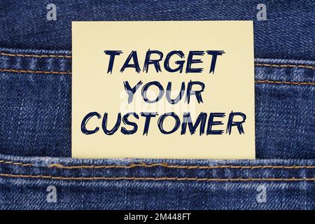 Economia e concetto di istruzione. Ci è una carta che sporge da una tasca dei jeans con l'iscrizione - Target il vostro cliente Foto Stock