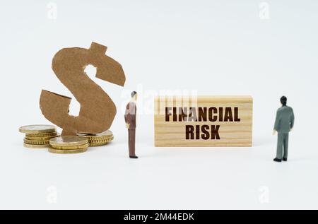 Economia e finanza. Su sfondo bianco, monete, simbolo del dollaro e figure di uomini d'affari che guardano un piatto di legno con l'iscrizione Foto Stock