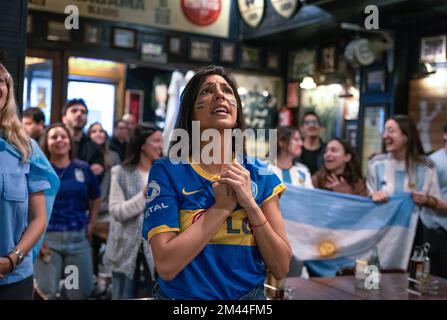 Una donna in una camicia Boca Juniors canta l'inno argentino durante la finale di Coppa del mondo contro la Francia. Almeno 100 argentini si sono riuniti al bar sonora di Barcellona per allietare la nazionale argentina nella finale di Coppa del mondo contro la Francia. Foto Stock