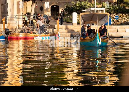 Birgu, Malta - 13 novembre 2022: I tradizionali taxi acquei maltesi, dghajsa, a cavallo turisti dalla stazione di sbarco Vittoriosa a la Valletta, in Foto Stock