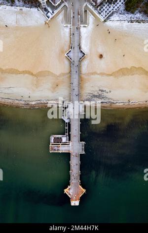 Vista aerea del molo in legno di Brzezno a Danzica, che si estende sul calmo Mar Baltico e sulla spiaggia sabbiosa Foto Stock