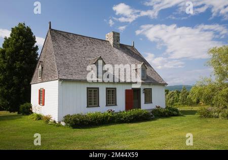 Vecchio regime francese 1752 legno bianco tavola con cedro scandole tetto casa stile cottage in estate, Saint-Francois, Ile d'Orleans, Quebec, Canada. Foto Stock