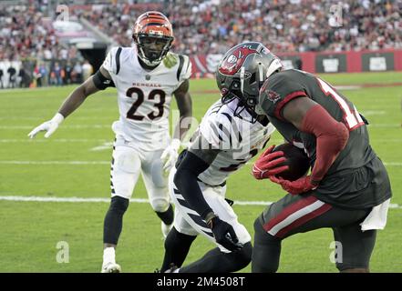 Tampa, Stati Uniti. 18th Dec, 2022. Il Russell Gage Jr. Di Tampa Bay Buccaneers prende un touchdown sotto la pressione di Dax Hill (23) dei Bengals di Cincinnati e di Cam Taylor-Britt (29) durante il primo tempo al Raymond James Stadium di Tampa, Florida, domenica 18 dicembre 2022. Foto di Steve Nesius/UPI Credit: UPI/Alamy Live News Foto Stock