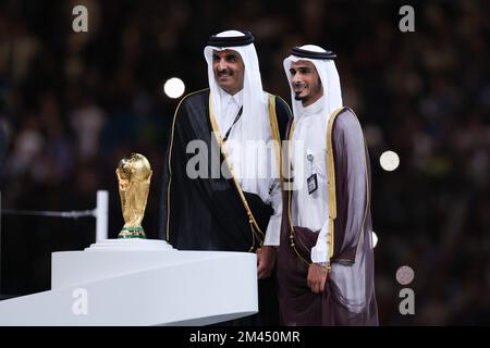 Doha, Qatar. 18th Dec, 2022. Il Qatar Emir Sheikh Tamim bin Hamad al-Thani (L) si pone sul palco con il trofeo di Coppa del mondo alla fine della finale di Coppa del mondo 2022 tra Argentina e Francia al Lusail Stadium di Lusail, a nord di Doha, il 18 dicembre 2022. (Foto: William Volcov) Credit: Brazil Photo Press/Alamy Live News Foto Stock