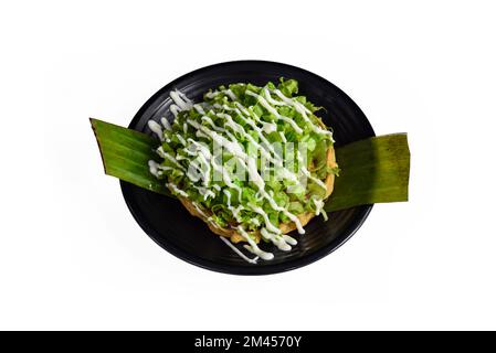 Piatto messicano Coyoacan su piastra nera vista dall'alto con pomodori ciliegini e peperoncino isolato su sfondo bianco Foto Stock