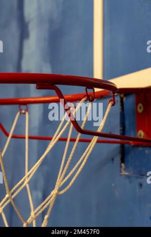 Backboard in plastica con cerchio rosso sul campo da basket all'aperto con raggi luminosi di sole Foto Stock