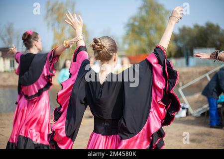 Danze zingari in abiti luminosi. Le ragazze ballano sulla danza spagnola di strada. Tessuto luminoso. La danza si muove. Foto Stock