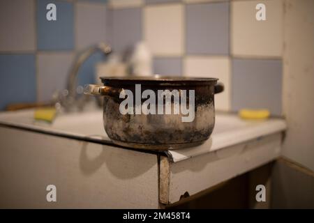 Vecchia padella sul lavandino. Piatti in cucina. Vecchia cucina in casa. Pentola bruciata. Foto Stock