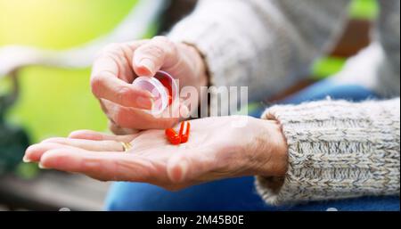 Lo odio, ma la sua importante. una donna anziana non riconoscibile che sta per prendere farmaci all'aperto in un parco durante il giorno. Foto Stock