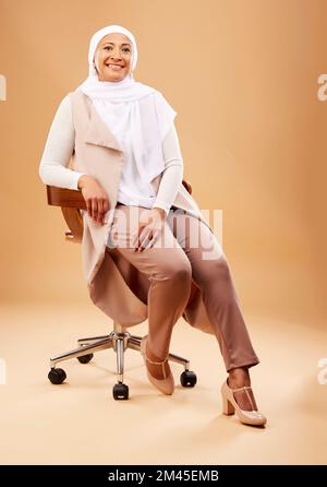 Moda, bellezza e donna musulmana su sedia in studio isolato su uno sfondo marrone. Trucco, cosmetici e ritratto di mature donne islamiche di Dubai Foto Stock