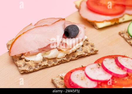 Diversi tipi di pane integrale con Prato, pomodoro, Rasth, cetriolo e formaggio. Colazione facile. Dieta alimentare. Panini veloci e sani. Croccante con gustoso ripieno. Snack dietetico sano Foto Stock