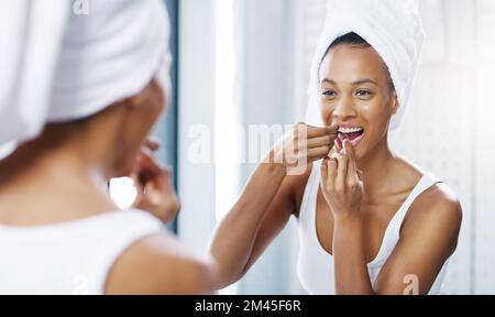 Ricordate sempre di far passare tutti. una giovane donna attraente che le gallina i denti mentre guarda lo specchio del bagno a casa. Foto Stock