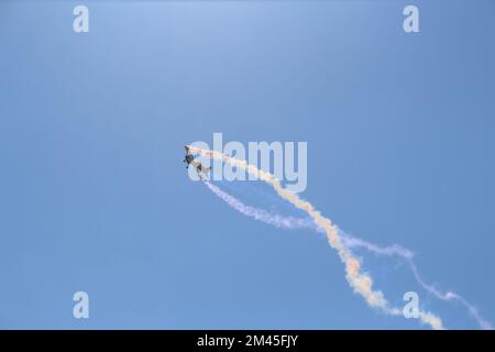 Un'inquadratura ad angolo basso di un aeroplano RC che vola in un cielo blu senza nuvole Foto Stock