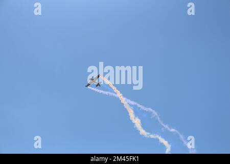 Un'inquadratura ad angolo basso di un aeroplano RC che vola in un cielo blu senza nuvole Foto Stock