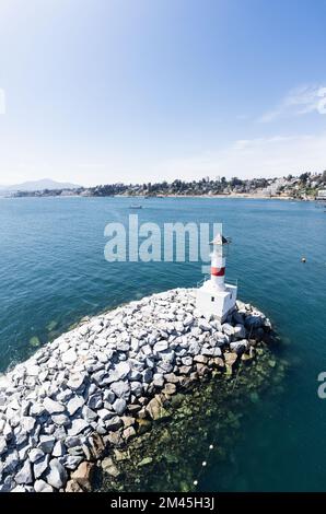 Uno scatto verticale di un faro sulla costa rocciosa Foto Stock